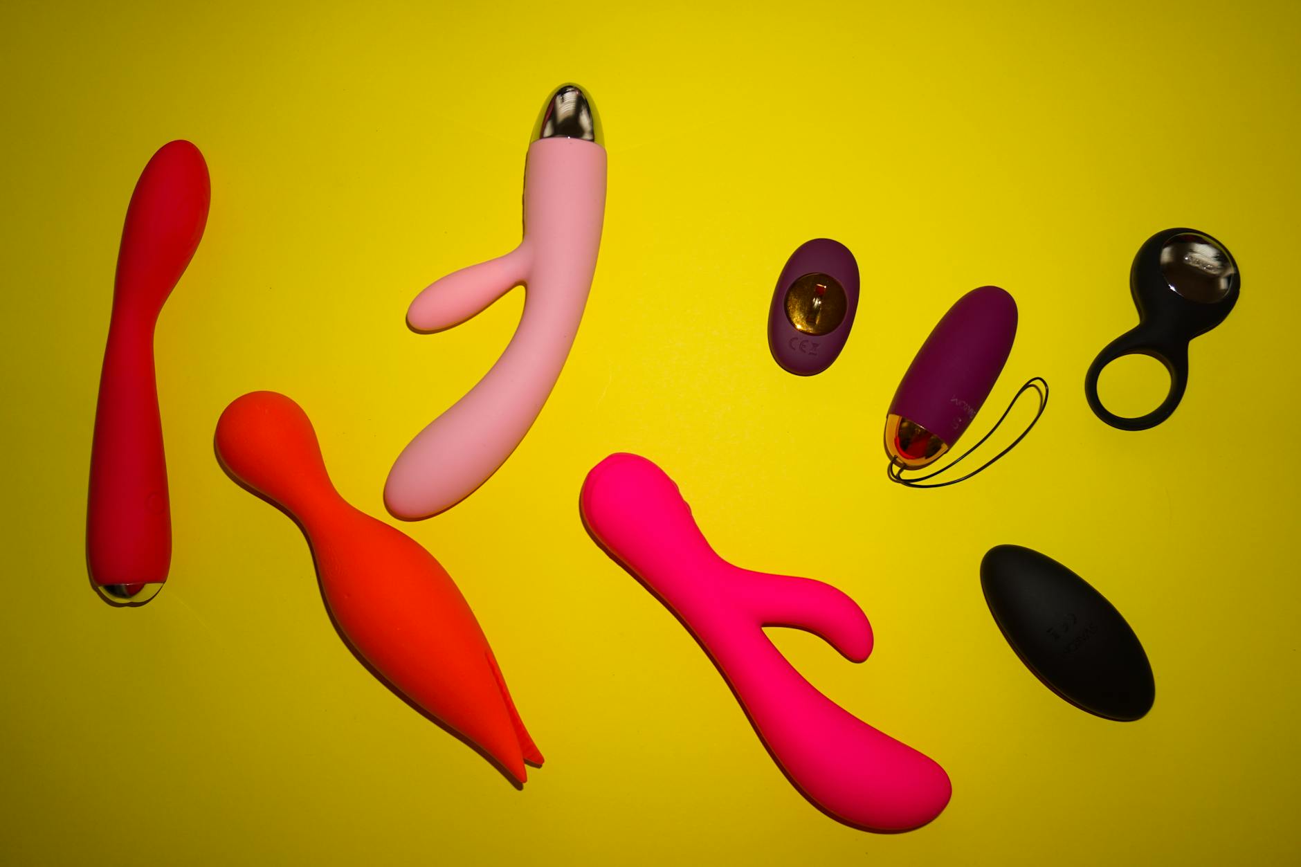 Vibrant colorful silicone toys arranged on bright yellow surface showcasing design diversity